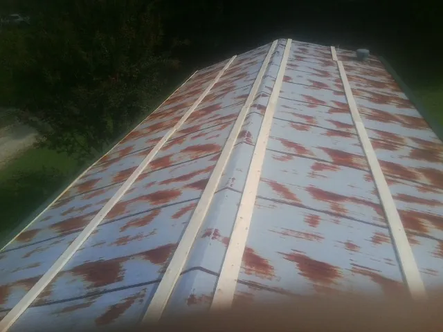 Rusted metal roof panels with new wood purlins before replacement — Storm Damage Roof Repair in Evans Mills by Roofing Brothers