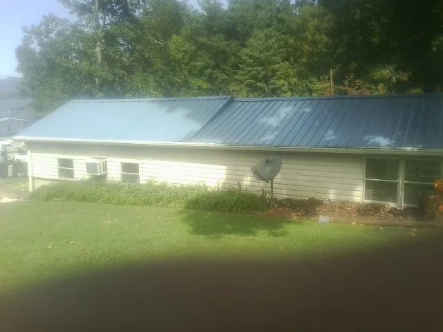 Blue metal roof running the length of a single story home in Evans Mills