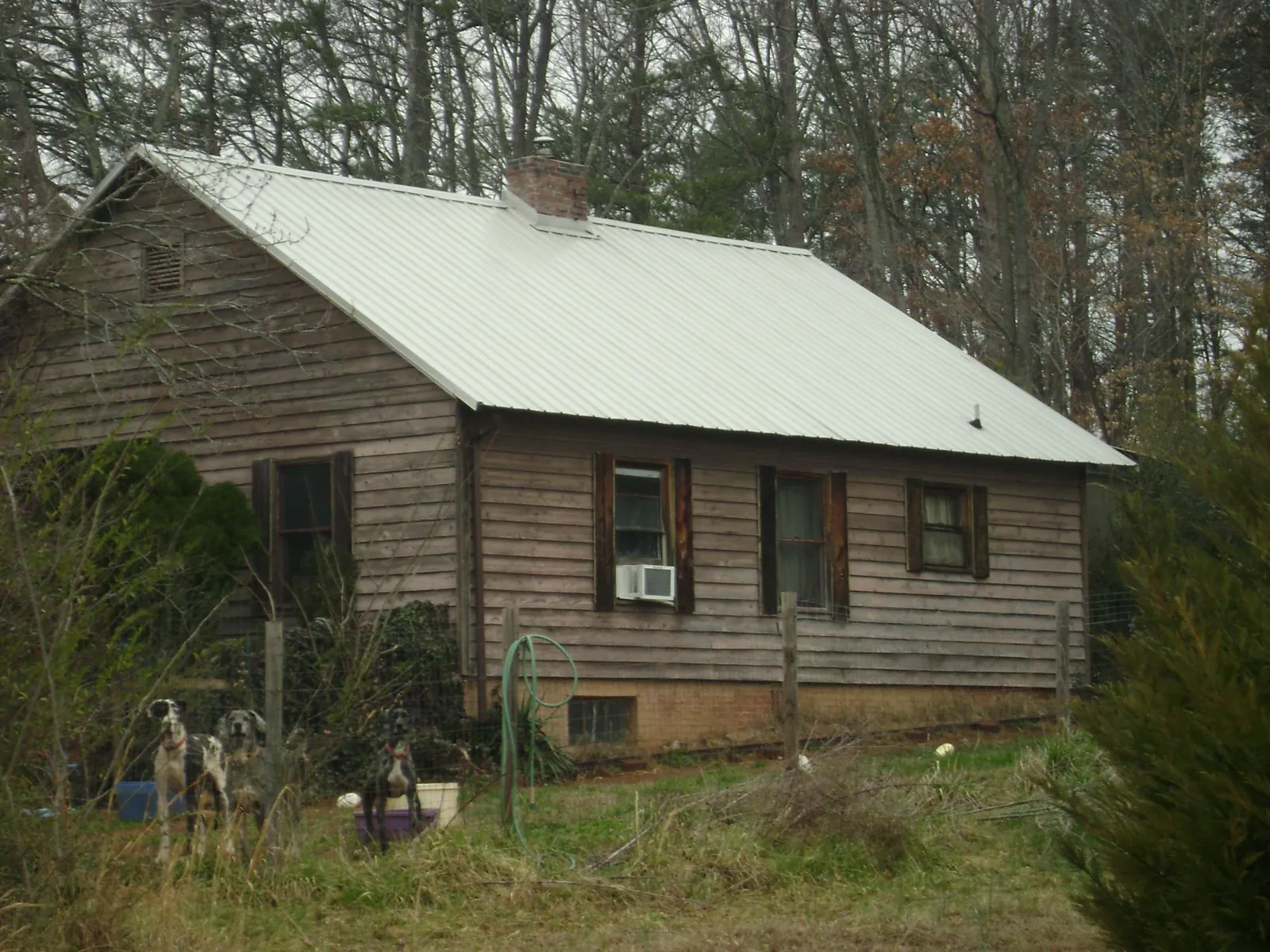 White metal roof on an old wood sided farmhouse, from a Metal Roof Installation job in Evans Mills